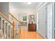 Bright foyer with hardwood floors, staircase, and a view into the living room at 210 Presidents Walk Ln, Cary, NC 27519