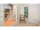 Hallway with hardwood floors, decorative chair, and access to a half bathroom at 210 Presidents Walk Ln, Cary, NC 27519
