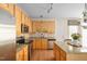 Well-lit kitchen featuring wooden cabinetry, stainless appliances, and granite countertops at 210 Presidents Walk Ln, Cary, NC 27519