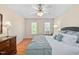 Relaxing main bedroom featuring a ceiling fan, hardwood floors, and large windows at 210 Presidents Walk Ln, Cary, NC 27519
