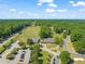 Sprawling aerial view highlighting the golf course, clubhouse, and surrounding community nestled amidst mature trees at 2105 Metacomet Way, Raleigh, NC 27604