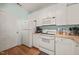 A cozy kitchen featuring white cabinets, appliances, and hardwood flooring for a classic look at 2105 Metacomet Way, Raleigh, NC 27604