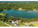 Expansive aerial view of lakefront property surrounded by lush greenery and mature trees at 215 Collins Rd, Lillington, NC 27546