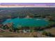 Stunning aerial view showcasing a beautiful lake house surrounded by lush trees and natural beauty at 215 Collins Rd, Lillington, NC 27546