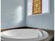 A luxurious white soaking tub is next to a stained glass window offering an artistic touch at 215 Collins Rd, Lillington, NC 27546