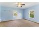 Spacious carpeted bedroom featuring a ceiling fan and two windows with natural light at 215 Collins Rd, Lillington, NC 27546