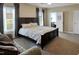 Comfortable bedroom with a wooden bed frame and large windows offering plenty of natural light at 215 Collins Rd, Lillington, NC 27546