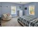 A bright bedroom with two large windows providing natural light, with a cozy chair for relaxation at 215 Collins Rd, Lillington, NC 27546