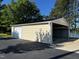Detached carport with enclosed storage adjacent to an asphalt drive and overlooking the lake at 215 Collins Rd, Lillington, NC 27546