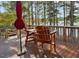 Wooden deck overlooking the lake with chairs, table and a shade umbrella at 215 Collins Rd, Lillington, NC 27546