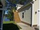 Tan vinyl siding and a long wooden staircase to an elevated deck are next to the lake at 215 Collins Rd, Lillington, NC 27546
