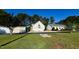 A detached two-car garage complements this home's exterior with a sunny lawn and trees in the background at 215 Collins Rd, Lillington, NC 27546