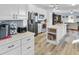 Bright kitchen features white cabinets, stainless appliances, tile backsplash, and an island at 215 Collins Rd, Lillington, NC 27546