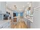 Open kitchen with white cabinets, modern appliances, large island, and wood-style floors at 215 Collins Rd, Lillington, NC 27546