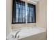 Bright bathroom featuring a large soaking tub with dark curtains and tiled walls at 220 Outwater Ridge Dr, Garner, NC 27529