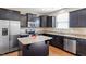 Modern kitchen boasts dark cabinets, stainless steel appliances, granite countertops, and an island at 220 Outwater Ridge Dr, Garner, NC 27529