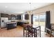 Well-appointed kitchen with dark cabinetry, granite countertops, a dining table and stainless steel appliances at 220 Outwater Ridge Dr, Garner, NC 27529