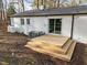 Back of house features a wooden deck with steps in a grass backyard at 2224 Clements Dr, Durham, NC 27704