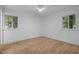 Bright, empty bedroom featuring hardwood floors and ample natural light from two windows at 2224 Clements Dr, Durham, NC 27704