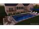 This backyard features a gorgeous pool, chairs, and blue umbrellas creating a luxurious outdoor oasis at 25 Westbourne Ln, Youngsville, NC 27596