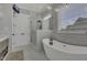 Bright bathroom with a soaking tub, glass shower, marble counters, and modern lighting fixtures at 25 Westbourne Ln, Youngsville, NC 27596