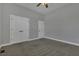 A neutral bedroom with carpet, ceiling fan and multiple closets and doors at 25 Westbourne Ln, Youngsville, NC 27596