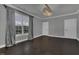 Spacious bedroom featuring dark hardwood floors, gray walls, and large window with gray curtains at 25 Westbourne Ln, Youngsville, NC 27596