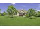 Traditional two-story home featuring a lush front lawn and mature trees creating a picturesque setting at 25 Westbourne Ln, Youngsville, NC 27596