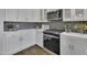 Close up of kitchen featuring stainless appliances, white cabinets, and designer backsplash at 25 Westbourne Ln, Youngsville, NC 27596