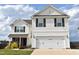 Charming two-story home featuring a two-car garage, neutral siding, and black shutters against a blue sky at 259 Brassfield Dr, Burlington, NC 27217