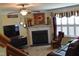 Cozy living room with fireplace, ceiling fan, and large TV, perfect for relaxing and entertaining at 259 Brassfield Dr, Burlington, NC 27217