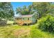 View of charming green home with a new wood deck and lush backyard under a blue sky at 2677 Nc-39, Henderson, NC 27537