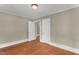 Empty bedroom features hardwood floors, neutral paint, and access to an adjacent room at 2677 Nc-39, Henderson, NC 27537