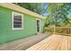 Wooden deck adjacent to a green home with backyard view and exterior access at 2677 Nc-39, Henderson, NC 27537