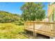 Wooden deck with railing overlooking a grassy yard, attached to a green house at 2677 Nc-39, Henderson, NC 27537