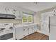 Well-lit kitchen with white appliances and cabinets, and natural light at 2677 Nc-39, Henderson, NC 27537