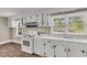Bright kitchen with hardwood flooring, white cabinets, and modern range hood at 2677 Nc-39, Henderson, NC 27537