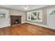 Bright living room with hardwood floors, a large window, a brick fireplace, and natural light at 2677 Nc-39, Henderson, NC 27537