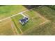 Aerial view highlighting a modern farmhouse with a fenced yard, long driveway, and landscaping at 2775 Eagles Roost Trl, Burlington, NC 27217