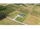 Aerial view showcasing a modern farmhouse with fenced yard, landscaping, and gravel driveway at 2775 Eagles Roost Trl, Burlington, NC 27217