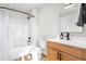 This bathroom features a shower and bath combination and a wood vanity with black hardware at 2775 Eagles Roost Trl, Burlington, NC 27217