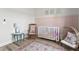 Bright Bedroom features pink trim, a white crib, an egg chair, and a rocking chair at 2775 Eagles Roost Trl, Burlington, NC 27217