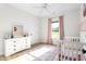 Bright Bedroom with natural light offers white dresser, pink accents, and a crib at 2775 Eagles Roost Trl, Burlington, NC 27217