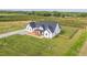 Exterior aerial view showcasing modern farmhouse, porch, gravel drive, and landscaped lawn at 2775 Eagles Roost Trl, Burlington, NC 27217