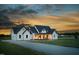 Beautiful modern farmhouse exterior with a welcoming front porch and a gravel driveway at 2775 Eagles Roost Trl, Burlington, NC 27217