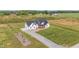 Exterior aerial view of a modern farmhouse with a spacious yard and a long driveway at 2775 Eagles Roost Trl, Burlington, NC 27217