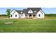 Charming two-story home features a spacious lawn, white siding, black roof, and inviting front porch at 2775 Eagles Roost Trl, Burlington, NC 27217