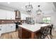 Kitchen boasts stainless steel appliances, a large island, stylish pendant lights, and white cabinets at 2775 Eagles Roost Trl, Burlington, NC 27217