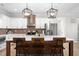 Bright kitchen features white cabinets, brick backsplash, stainless steel appliances, and island with seating at 2775 Eagles Roost Trl, Burlington, NC 27217