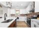 A kitchen view highlights white cabinets and a brick backsplash with wood floors at 2775 Eagles Roost Trl, Burlington, NC 27217